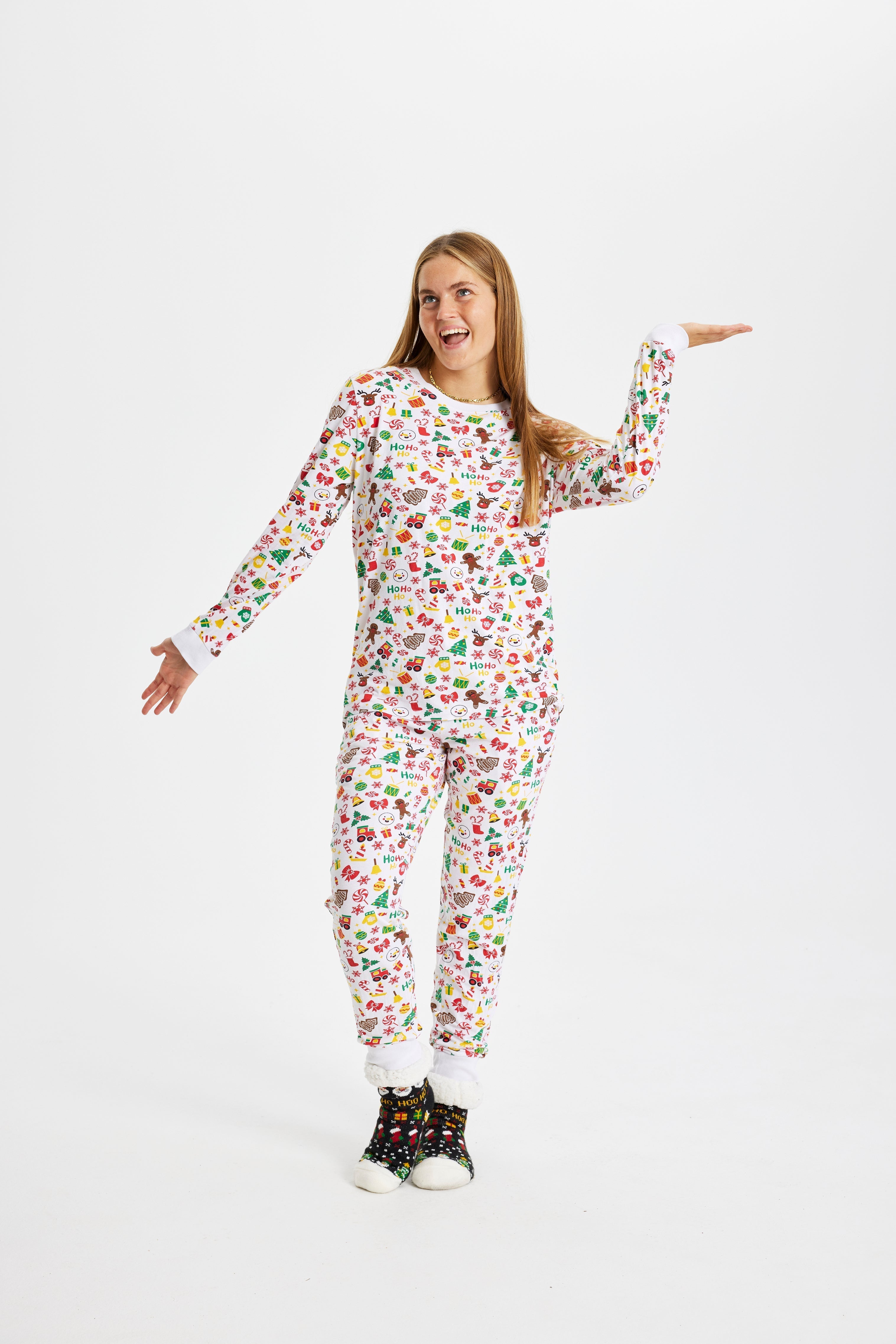 En poserande kvinna i vit julpyjamas.